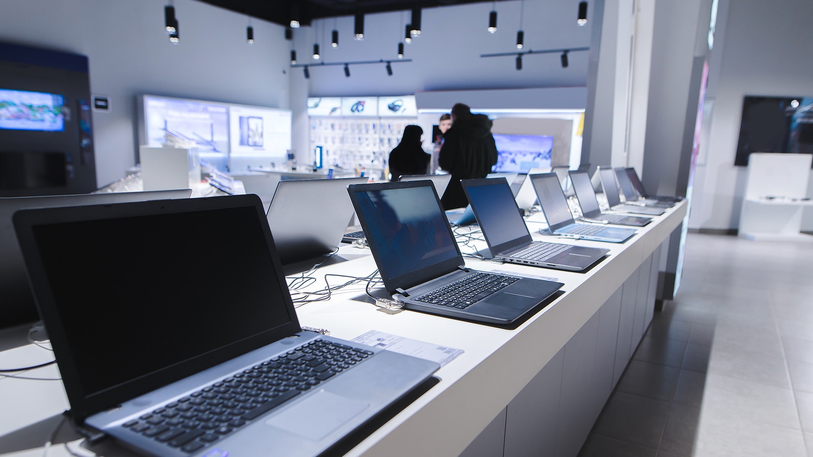 Laptops in a modern technology store. Department of computers in the electronics store. Choosing a laptop in the store.
